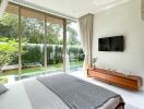 Modern bedroom with large windows overlooking a garden and pool