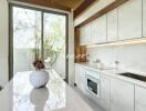 Modern kitchen with white cabinets, built-in appliances, and large window