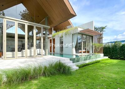 Modern house with floor-to-ceiling windows, outdoor pool, and green lawn