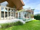 Modern house with floor-to-ceiling windows, outdoor pool, and green lawn