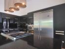 Modern kitchen with black cabinetry and stainless steel appliances