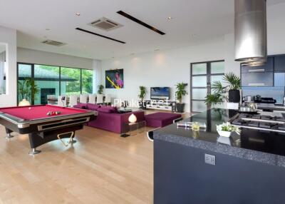 Spacious living area with pool table and modern kitchen