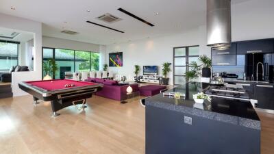 Spacious living area with pool table and modern kitchen