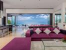 Modern living room with ocean view, purple sofa, and open kitchen