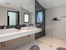 Modern bathroom with double sinks and glass-enclosed shower