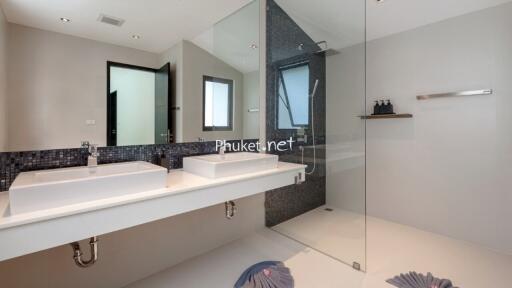 Modern bathroom with double sinks and glass-enclosed shower