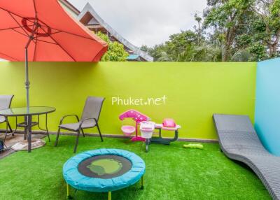 Colorful outdoor area with seating, umbrella, and children