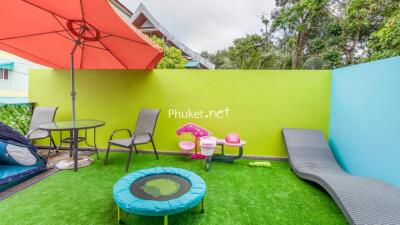 Colorful outdoor area with seating, umbrella, and children