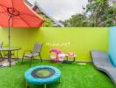 Colorful outdoor area with seating, umbrella, and children's play equipment