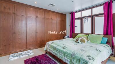 Spacious bedroom with wooden wardrobes and a king-sized bed