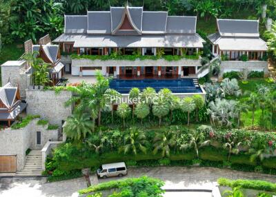 Panoramic view of a luxury villa surrounded by lush greenery with an outdoor pool