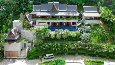 Panoramic view of a luxury villa surrounded by lush greenery with an outdoor pool