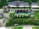 Panoramic view of a luxury villa surrounded by lush greenery with an outdoor pool