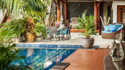 Luxurious outdoor patio with poolside seating and lush greenery