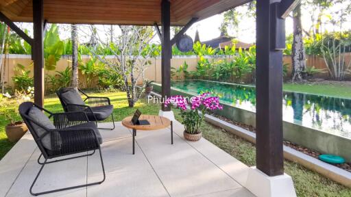 Cozy covered patio with seating area and view of a swimming pool