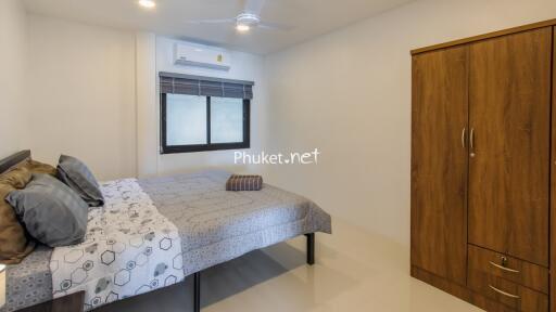 cozy bedroom with wooden wardrobe and bed