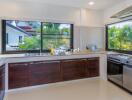 Modern kitchen with large windows and stainless steel appliances