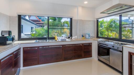 Modern kitchen with large windows and stainless steel appliances