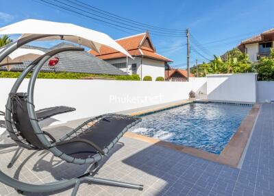 Swimming pool with lounge chairs and umbrella