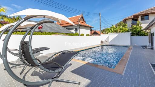 Swimming pool with lounge chairs and umbrella