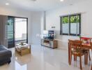 Modern living room with sofa, coffee table, TV, and dining area