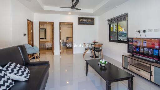 Modern living room with black sofa, coffee table, and TV