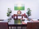 Modern dining room with wooden table and chairs, decorated with paintings and plants