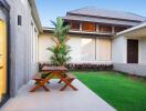 Outdoor patio area with garden view and wooden picnic table