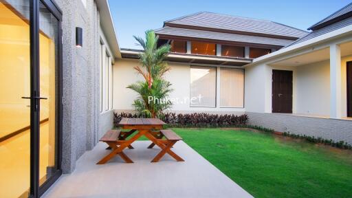 Outdoor patio area with garden view and wooden picnic table