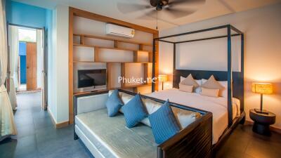 Spacious bedroom with king-size bed, seating area, and modern amenities