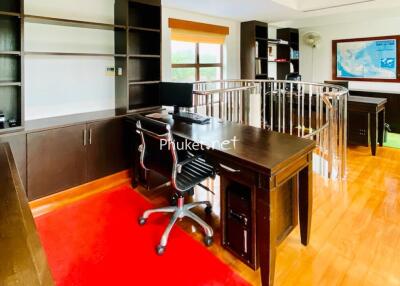 Spacious home office with wooden furniture and red carpet