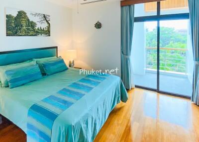 Bright bedroom with teal bedding and large window