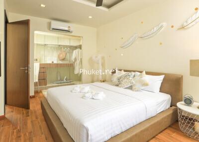 Cozy and well-decorated bedroom with neutral tones, modern furnishings, and wooden flooring