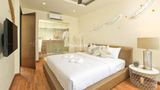 Cozy and well-decorated bedroom with neutral tones, modern furnishings, and wooden flooring