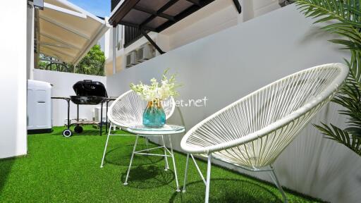 Small outdoor patio with chairs and a barbecue grill