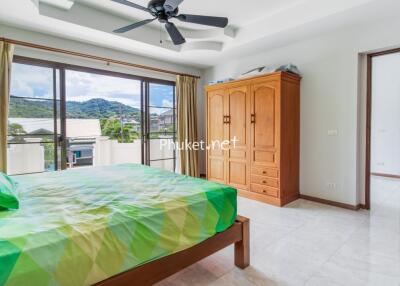 Spacious bedroom with a large window and mountain view