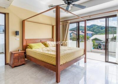 Spacious bedroom with four-poster bed and balcony view