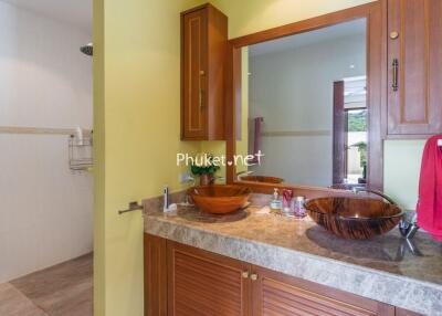 Well-lit bathroom with wooden cabinets and vessel sinks