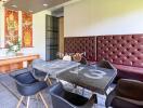 Dining area with modern chairs, table, and decorative art on the wall