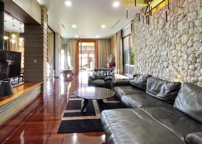 Spacious living room with stone accent wall and modern furnishings