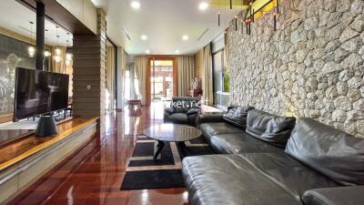 Spacious living room with stone accent wall and modern furnishings