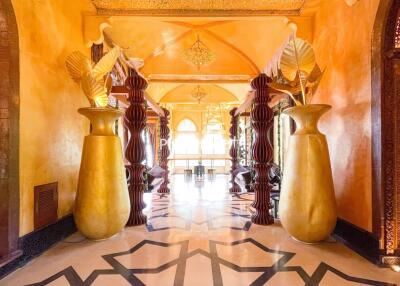 Elegantly decorated hallway with sculpted columns and large vases