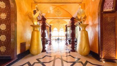 Elegantly decorated hallway with sculpted columns and large vases