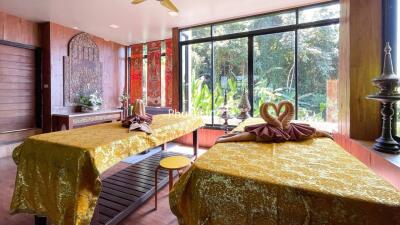 A well-decorated massage room with large windows and nature view