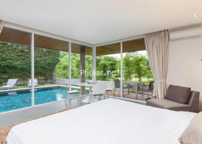 Modern bedroom with a view of the backyard pool