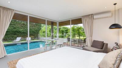 Modern bedroom with a view of the backyard pool