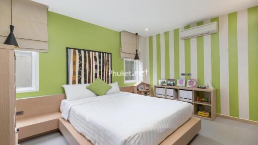 Modern bedroom with green accent walls and minimalist furniture