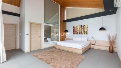 Modern bedroom with platform bed, artwork, and large glass window