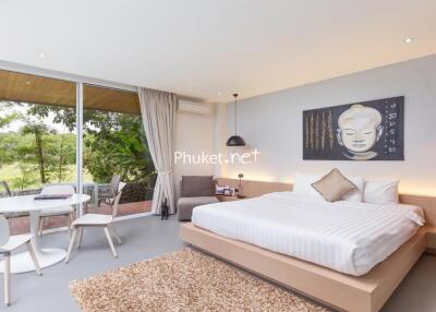 Modern bedroom with large window and Buddha wall art