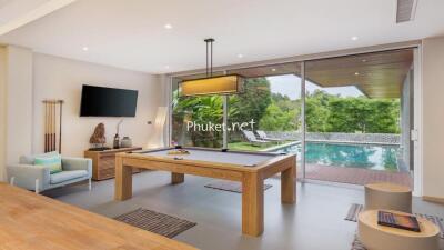 Modern living area with pool table and view of the outdoor pool and greenery